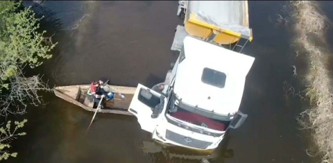 Suyla dolan yolda mahsur kalan TIR şoförü sandalla kurtarıldı