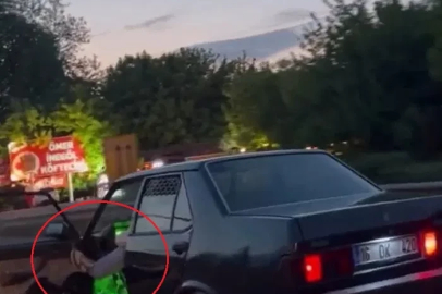 Otomobilinin sol ön kapısını açıp, ayağıyla tutarak trafikte ilerledi
